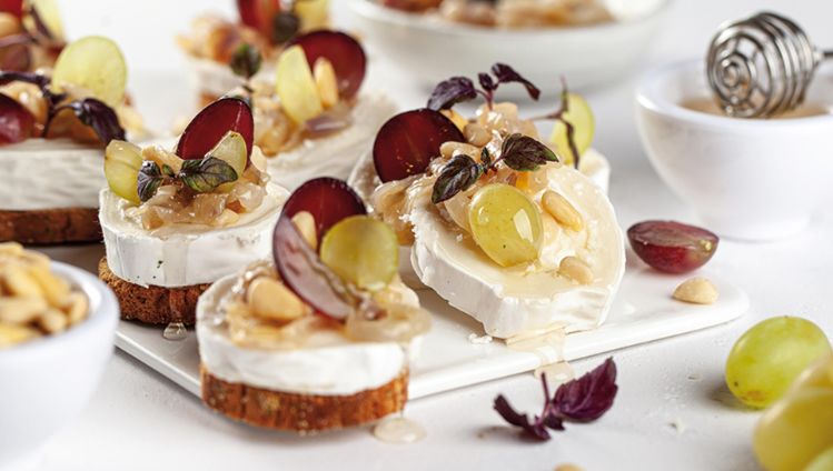 Geitenkaas op toast met gekarameliseerde rode uien, druiven, honing en pijnboompitten