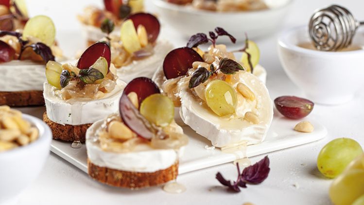 Geitenkaas op toast met gekarameliseerde rode uien, druiven, honing en pijnboompitten